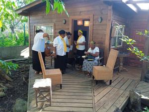 a group of people standing outside of a cabin at casa de huéspedes selvatica in Utila