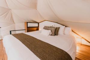 1 dormitorio con 1 cama blanca en una tienda de campaña en Ananta Forest - Glamping Dome - Hot Tub - Sunset & Gulf View, en Monteverde