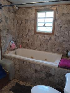 baño con bañera y ventana en casa de huéspedes selvatica, en Utila