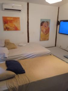 a bedroom with two beds and a computer monitor at casa de huéspedes selvatica in Utila