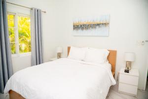 une chambre avec un lit blanc et une fenêtre dans l'établissement Trade Winds Cottage #1, à Cedar Grove 6 autres photos