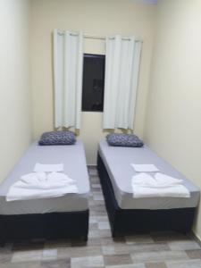two beds in a small room with white sheets at Lucas e Bida in Imbau