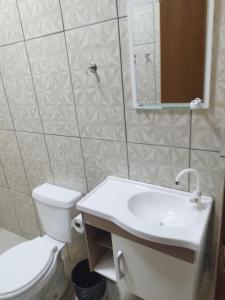 a white bathroom with a toilet and a sink at Lucas e Bida in Imbau