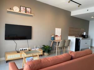 Trefoil Studio Comfy 3-Shah Alam في شاه عالم: غرفة معيشة مع أريكة وتلفزيون بشاشة مسطحة