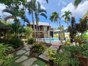 聖維森特的住宿－NATIVO D' KUBO，一个带游泳池和棕榈树的度假村