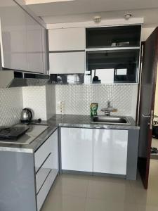 a kitchen with white cabinets and a sink at 温馨小屋18 in Bandung