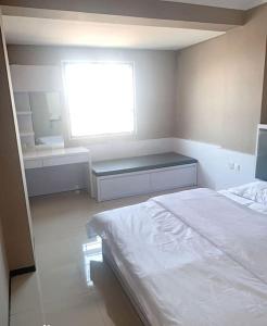a bedroom with a white bed and a window at 温馨小屋18 in Bandung