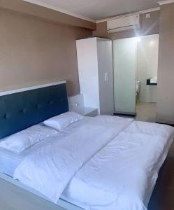 a large white bed with a blue headboard in a room at 温馨小屋18 in Bandung