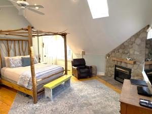 1 dormitorio con 1 cama y chimenea en Goldberry Woods- A Modern Farm Resort, en Union Pier