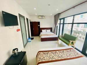 a hotel room with two beds and a tv at GIANG HÂN HOTEL in Tây Ninh