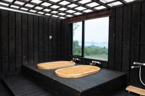a bathroom with two wooden sinks on a platform with a window at 丘の上から海が見える一棟貸しヴィラ しまいろ長手 