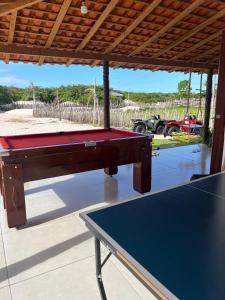 uma mesa de bilhar debaixo de um pavilhão em Pacas Suítes Casa & Chalés em Santo Amaro