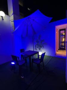 una camera blu con tavolo, sedie e ombrellone di Hotel Reggia a Tacna