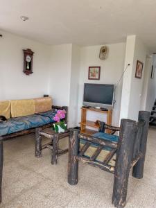 een woonkamer met een bank en een tv bij Finca con espectacular zona verde y hermosa vista a la piedra in Guatapé