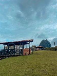 een paviljoen in een veld met een berg op de achtergrond bij Finca con espectacular zona verde y hermosa vista a la piedra in Guatapé