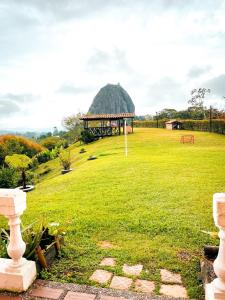 een tuinhuisje in het midden van een grasveld bij Finca con espectacular zona verde y hermosa vista a la piedra in Guatapé