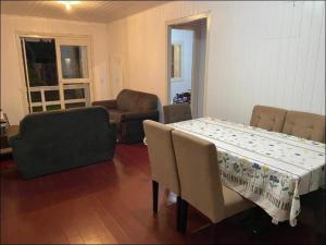 uma sala de estar com uma mesa e cadeiras e um sofá em Casa de férias! em Capão da Canoa