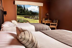two beds in a room with a window at Cuesta Serena Boutique Hotel in Huaraz