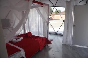 Santa Helena的住宿－Eco Cabañas Montana，窗户客房内的一张红色的床