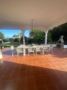 un patio con mesa y sillas en un suelo de baldosa en Marbella large rustic family villa to rent, en Estepona