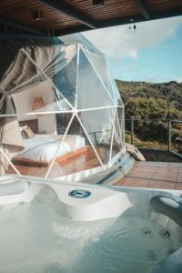 eine Badewanne mit einem Bett auf einem Boot in der Unterkunft Ananta Forest - Glamping Dome - Hot Tub - Sunset & Gulf View in Monteverde Costa Rica