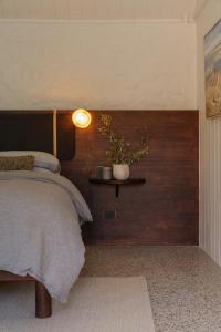 a bedroom with a bed and a shelf with a plant at Pago Middleton in Middleton