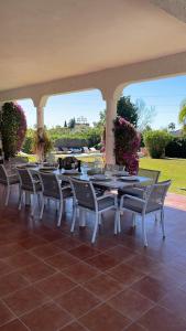 una mesa y sillas en un patio con flores en Marbella large rustic family villa to rent, en Estepona