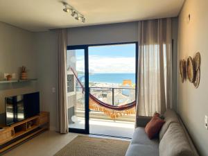 sala de estar con sofá y vistas al océano en Bossa Mar Apartamento, en Bombinhas