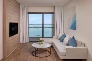 sala de estar con sofá blanco y ventana grande en Luxury 5 Star A La Carte Residence Ha Long en Ha Long