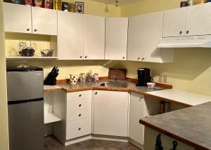 a kitchen with white cabinets and a sink at Gabriola Island B&B By The Sea in Gabriola