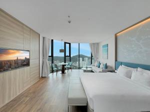 a bedroom with a large bed and a living room at Luxury 5 Star A La Carte Residence Ha Long in Ha Long