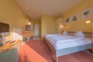 a bedroom with a large white bed and a desk at Strandläufer 114 in Granzow +5 photos