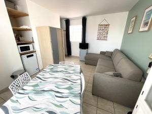 ein Wohnzimmer mit einem Sofa und einem Tisch in der Unterkunft Maison La Tranche-sur-Mer, 2 pièces, 4 personnes - FR-1-22-256 in La Tranche-sur-Mer