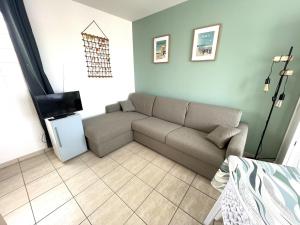 - un salon avec un canapé et une télévision dans l'établissement Maison La Tranche-sur-Mer, 2 pièces, 4 personnes - FR-1-22-256, à La Tranche-sur-Mer