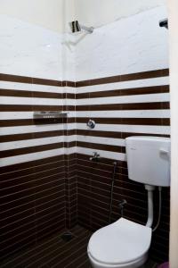 a bathroom with a toilet and black and white stripes at Kochu Mariya Residency in Punalūr