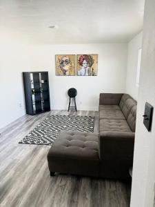 - un salon avec un canapé brun et un tapis dans l'établissement Cozy and Spacious Home, à Las Vegas