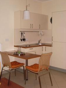- une cuisine avec une table, 2 chaises et un évier dans l'établissement Strandläufer Classic 106, à Granzow