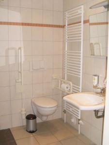 La salle de bains blanche est pourvue de toilettes et d'un lavabo. dans l'établissement Strandläufer Classic 106, à Granzow