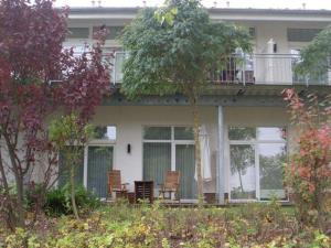 une maison avec 2 chaises sur la terrasse couverte dans l'établissement Strandläufer Classic 106, à Granzow