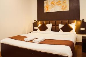 een slaapkamer met een groot bed en 2 handdoeken bij Hotel Siddhi Vinayak Regency, Mg Marg in Gangtok