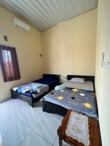 a room with two beds and a window at KBI Hostel in Ternate
