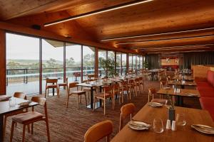 a restaurant with wooden tables and chairs and windows at Iron Creek Bay Estate in Sorell