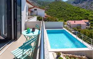 a balcony with a table and a swimming pool at Awesome Home In Lukovo With Sauna in Lukovo +28 photos
