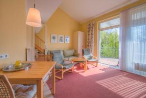 a living room with a couch and a table at Schneeeule 201 in Granzow