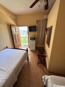 1 dormitorio con 1 cama y puerta a la cocina en Panchos Villas, en Caye Caulker