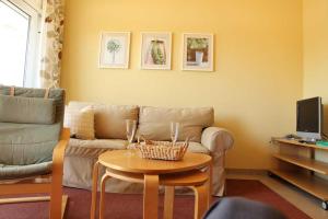 a living room with a couch and a table at Schneeeule 209 in Granzow