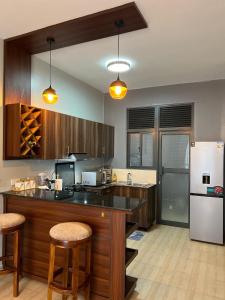 a kitchen with wooden cabinets and a white refrigerator at Bella Vista in Wakiso
