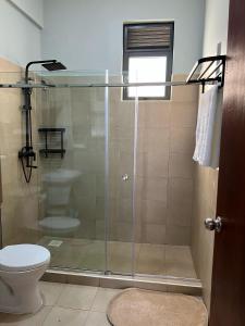 a bathroom with a glass shower with a toilet at Bella Vista in Wakiso