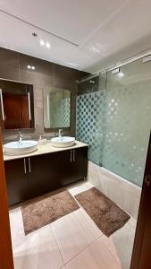 a bathroom with two sinks and a glass shower at hilton apartement families in Tangier