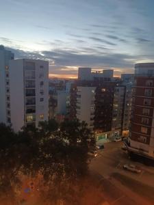 a view of a city at sunset with buildings at Apto Centrico Zona Tres Cruces in Montevideo